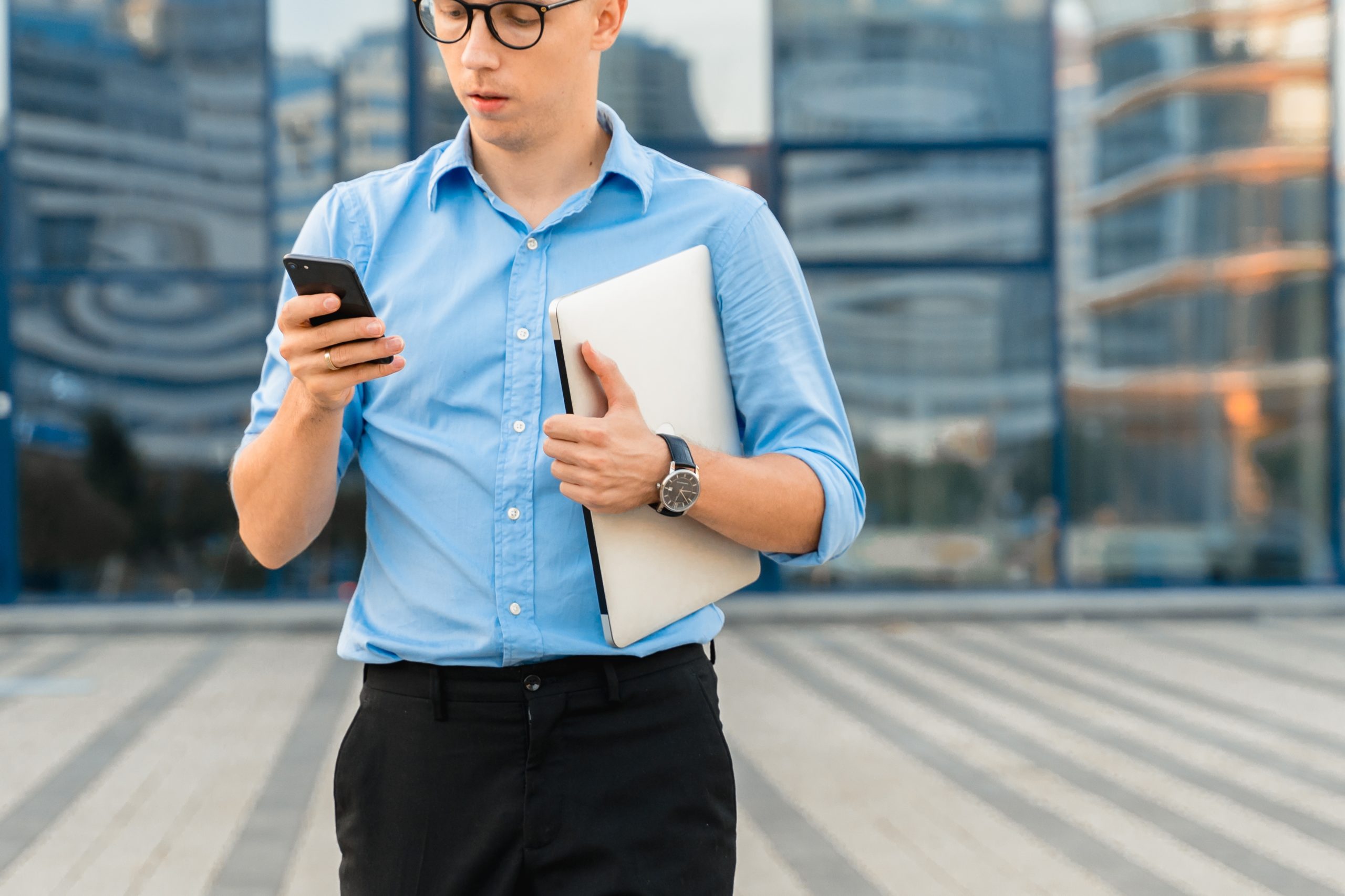 Businessman looking at phone and holding notepad