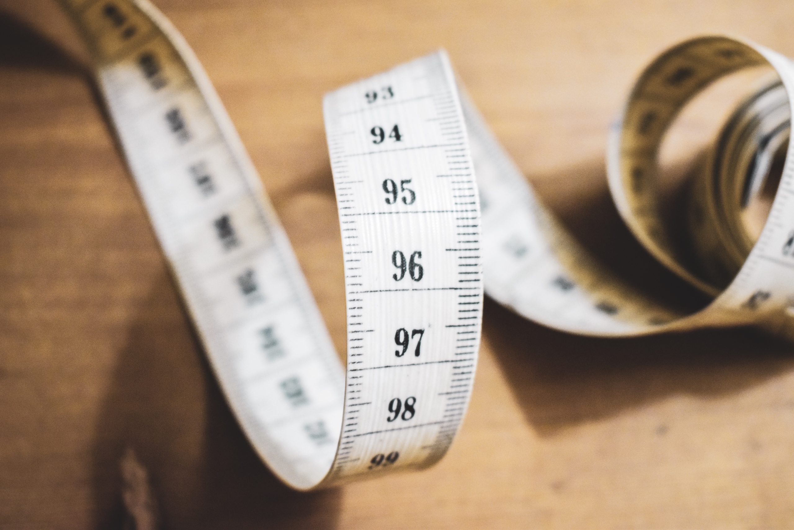 Unspooling measuring tape on wooden table