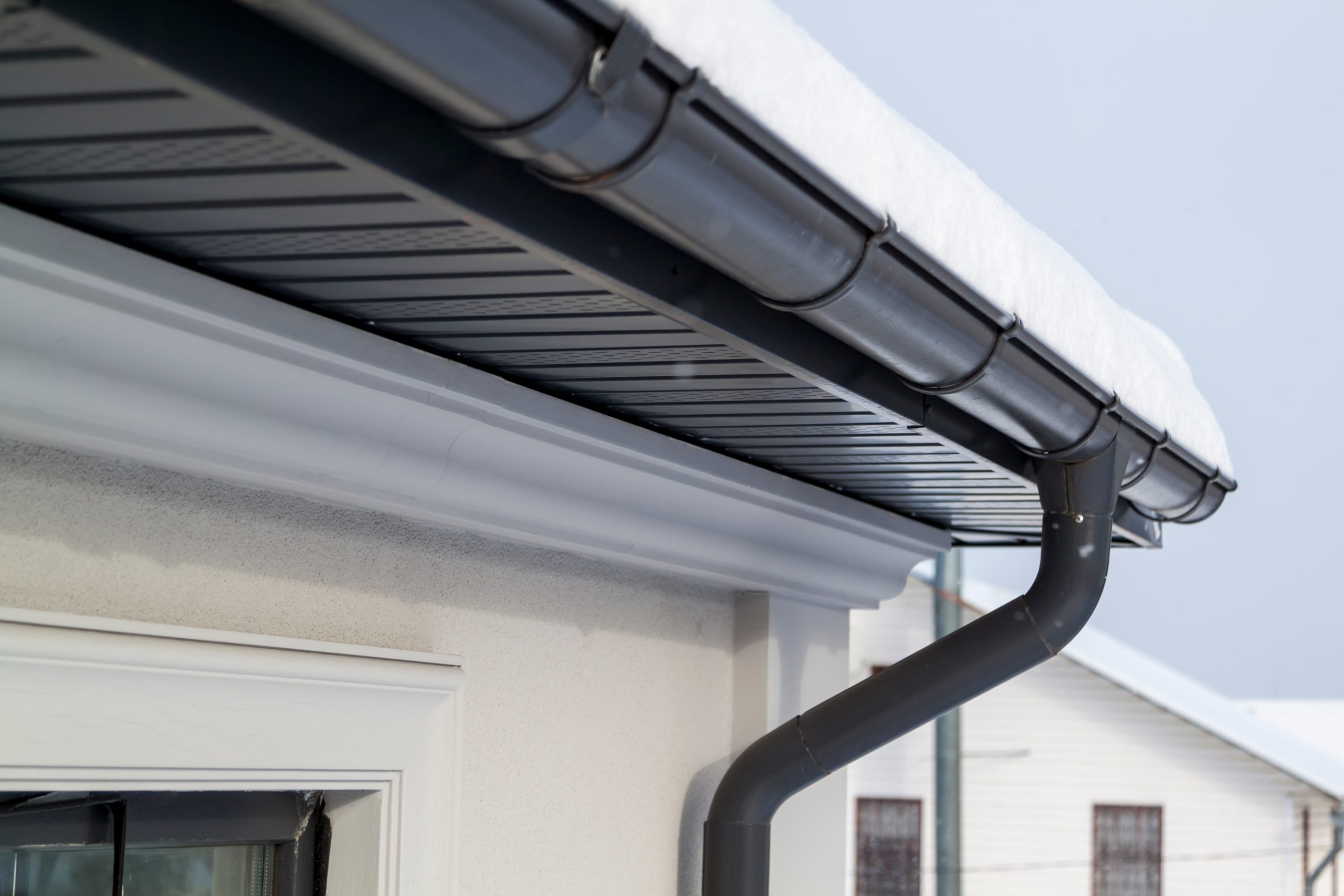 Corner of house with gray roof gutter