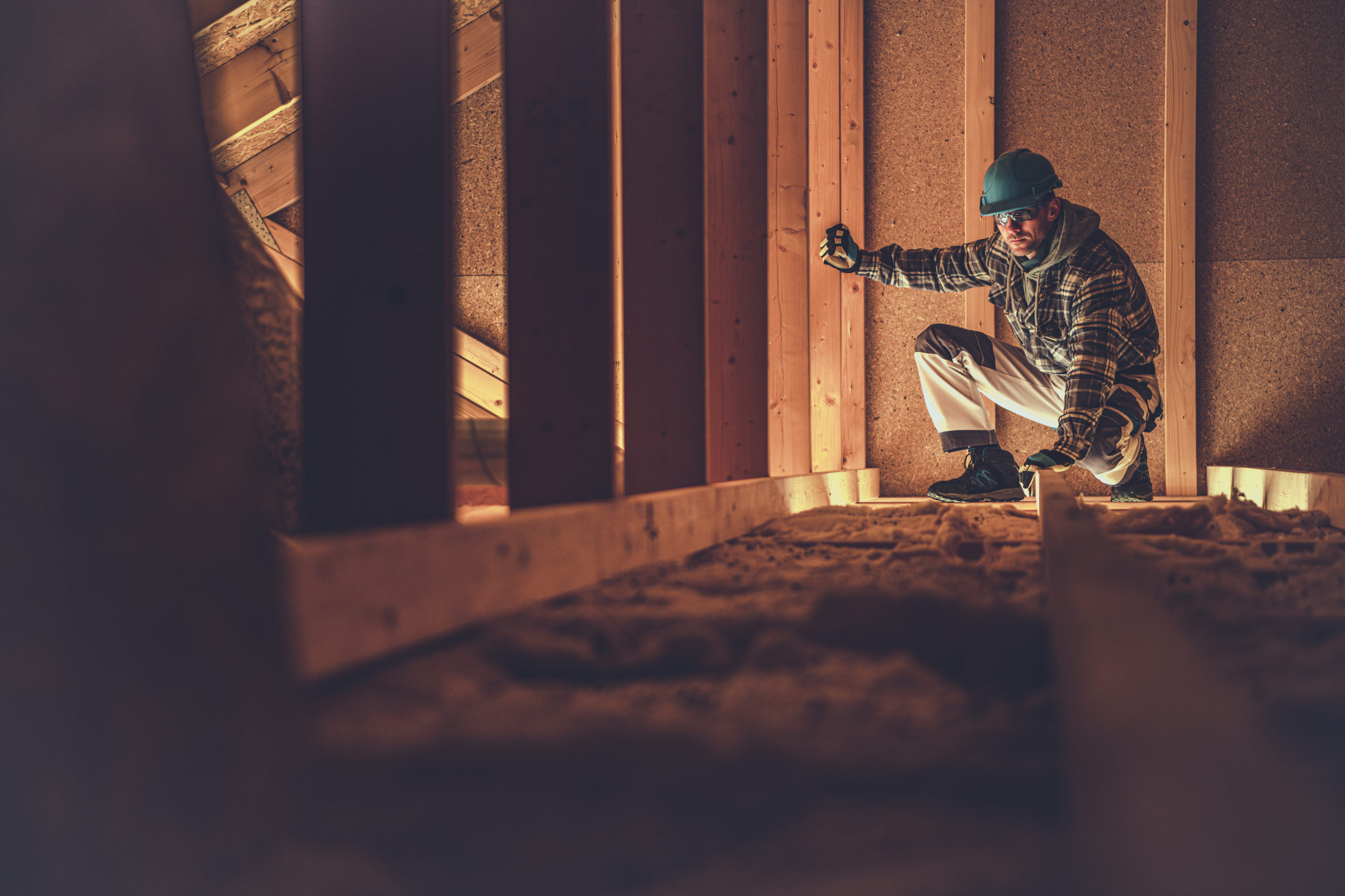 Roofing contractor inspecting a wooden attic