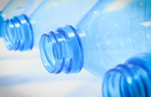 Tops of blue plastic water bottles laying sideways